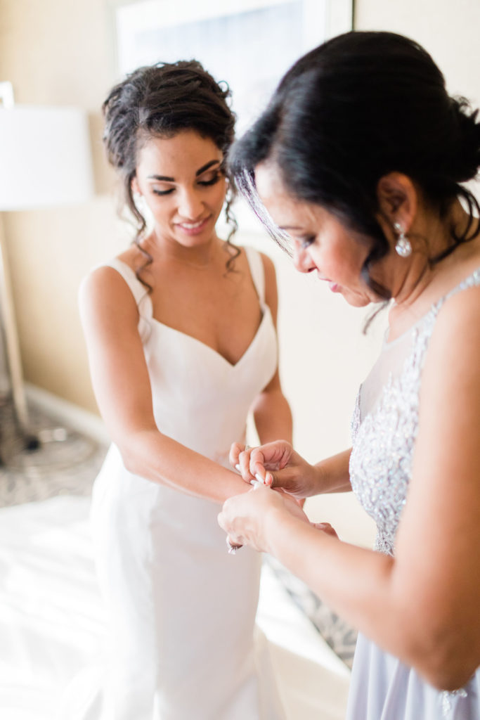 mom of bride helping put on wedding bracelet on the bride's wrist